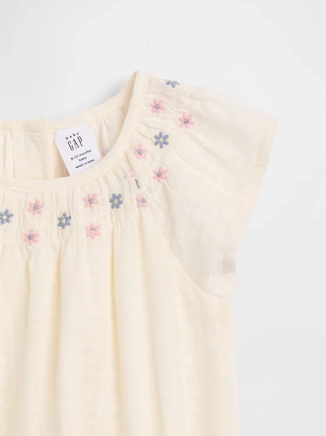 Baby-body med smock og blomstermønster