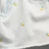 Barneshorts i lav midje med broderi i sitronfarget denim