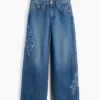 Barnjeans med lav midje, bred benvidde og brodert blomstermønster