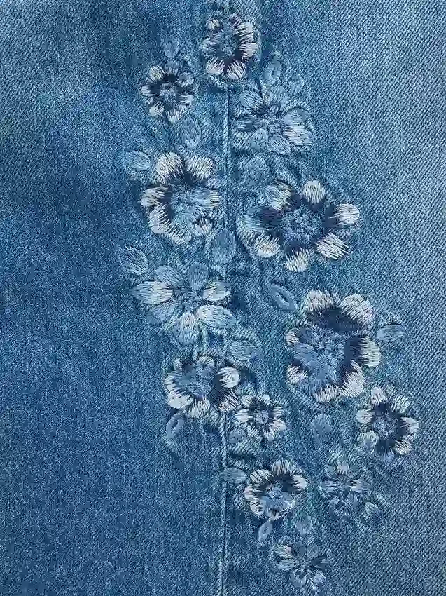 Barnjeans med lav midje, bred benvidde og brodert blomstermønster